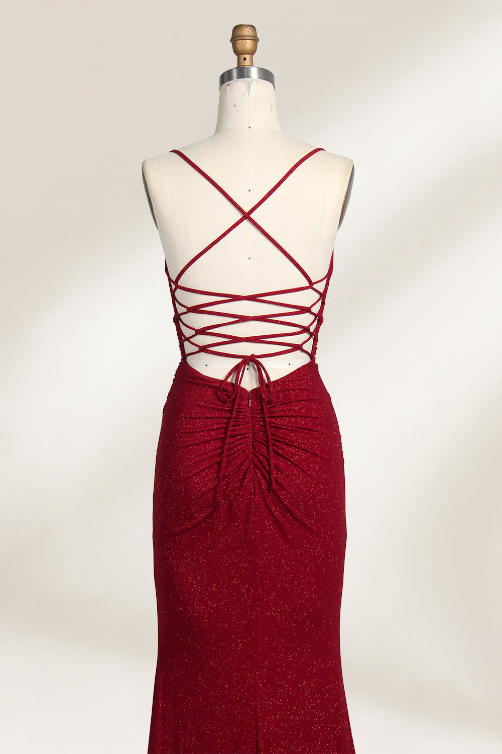 A mannequin showcases a royal - blue, glittery gown. It has thin straps, a ruched bodice, and a high side slit with a subtle train. The elegant design, with shimmering fabric, suits formal events like galas or proms, radiating sophistication.6
