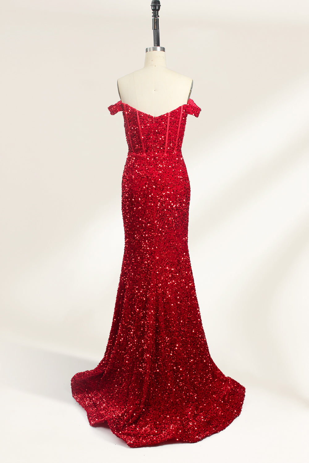 A photograph of a mannequin showcasing an off-the-shoulder, floor-length red sequin gown with a plunging V-neckline. The dress has a fitted bodice and a flared skirt, creating a glamorous, elegant appearance. The mannequin stands against a plain white background, emphasizing the dress's vibrant color and intricate details.02