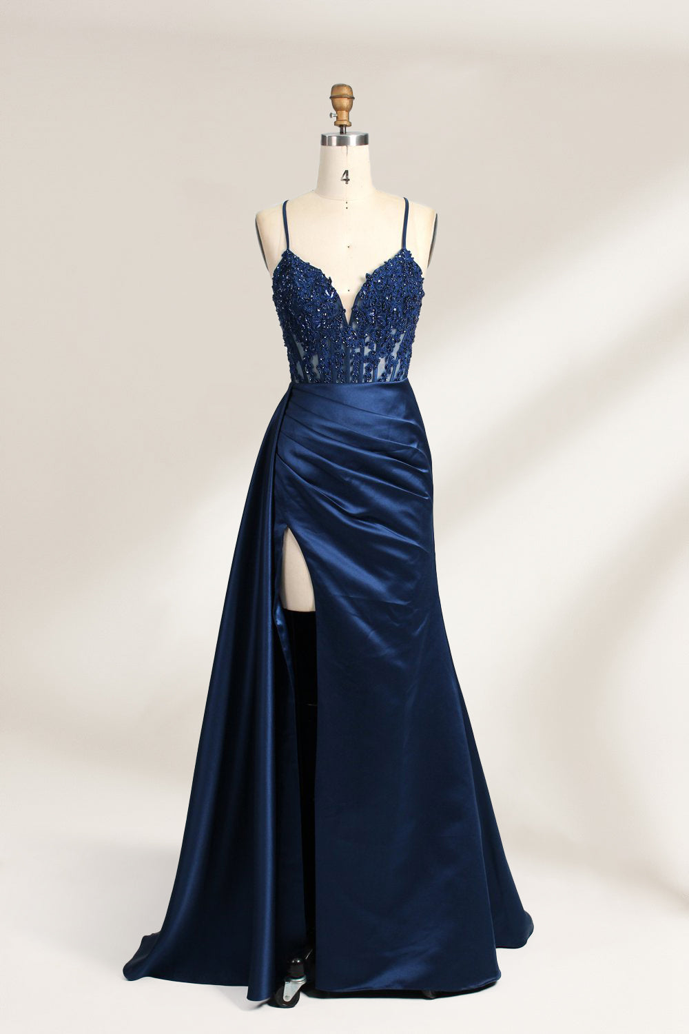 A mannequin showcases a royal - blue gown with thin straps. The bodice features intricate bead embroidery and sheer panels, while the skirt has a ruched design and a high side slit. The satin fabric and elegant details make it perfect for formal events like proms or galas, exuding sophistication.10