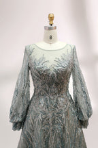 Presented on a mannequin is a deep - red evening gown. It features a sheer neckline, long billowy sleeves, and intricate gold - toned embroidery throughout. The elaborate design gives off a luxurious and elegant vibe, ideal for formal occasions.4