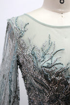 Presented on a mannequin is a deep - red evening gown. It features a sheer neckline, long billowy sleeves, and intricate gold - toned embroidery throughout. The elaborate design gives off a luxurious and elegant vibe, ideal for formal occasions.8