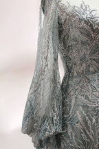 Presented on a mannequin is a deep - red evening gown. It features a sheer neckline, long billowy sleeves, and intricate gold - toned embroidery throughout. The elaborate design gives off a luxurious and elegant vibe, ideal for formal occasions.9