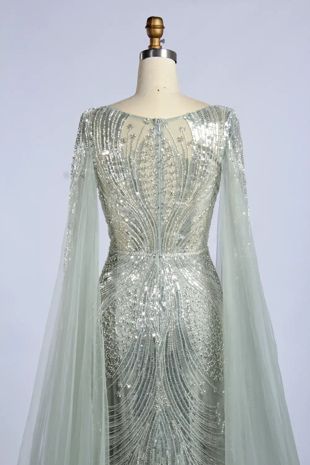 Silver beaded back cape fit-and-flare gown with sheer sleeves and embellished bodice