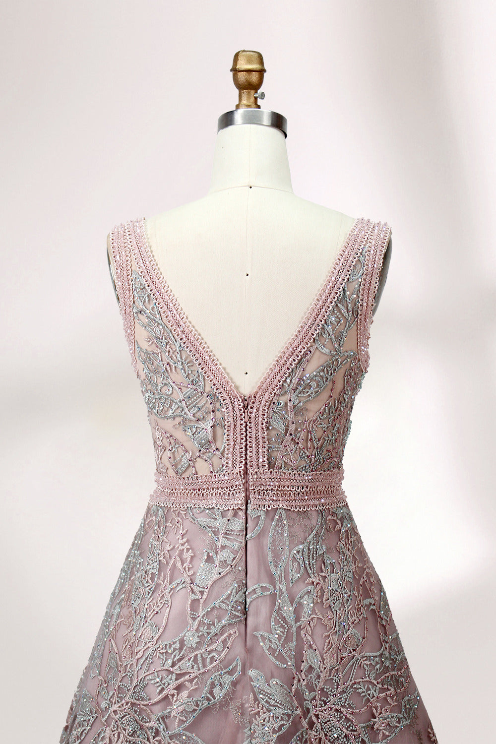 Displayed on a mannequin is a pink - hued evening gown. It features a deep V - neckline, intricate floral embroidery in shades of blue and pink, and a flowing skirt. The elegant design creates a romantic and sophisticated look, perfect for formal events.5