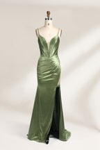 A mannequin showcases an olive - green satin gown. It has thin straps, a deep V - neck, ruched bodice, and a high side slit with sheer details. The elegant design, blending satin and intricate ruching, suits formal events like galas or proms, radiating sophistication.1