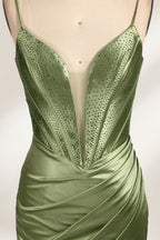 A mannequin showcases an olive - green satin gown. It has thin straps, a deep V - neck, ruched bodice, and a high side slit with sheer details. The elegant design, blending satin and intricate ruching, suits formal events like galas or proms, radiating sophistication.3