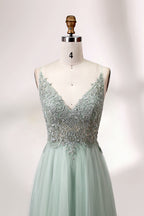 A mannequin showcases a light - green tulle gown with a lace - embroidered, sheer bodice. It has thin straps, a deep V - neckline, and a voluminous skirt. The delicate lace and flowing tulle create a romantic look, perfect for formal events like weddings or proms, exuding elegance.
4