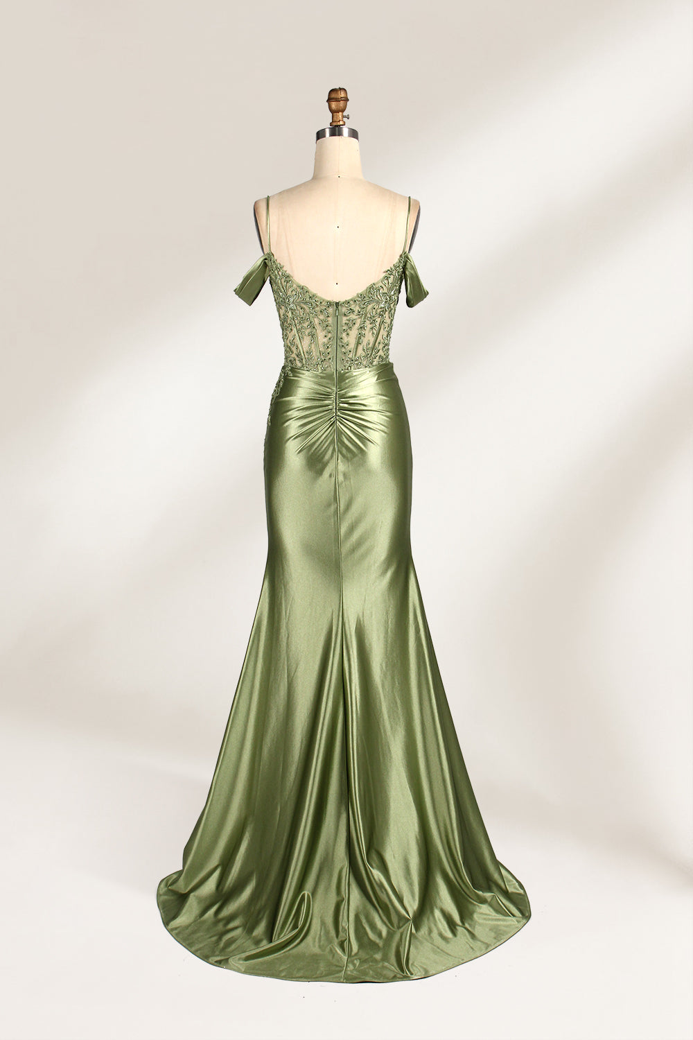 A mannequin displays a rose - gold satin gown. It has thin straps, off - shoulder lace - detailed sleeves, a ruched bodice, and a high side slit. The elegant design, blending satin and lace, suits formal events like galas or weddings.2