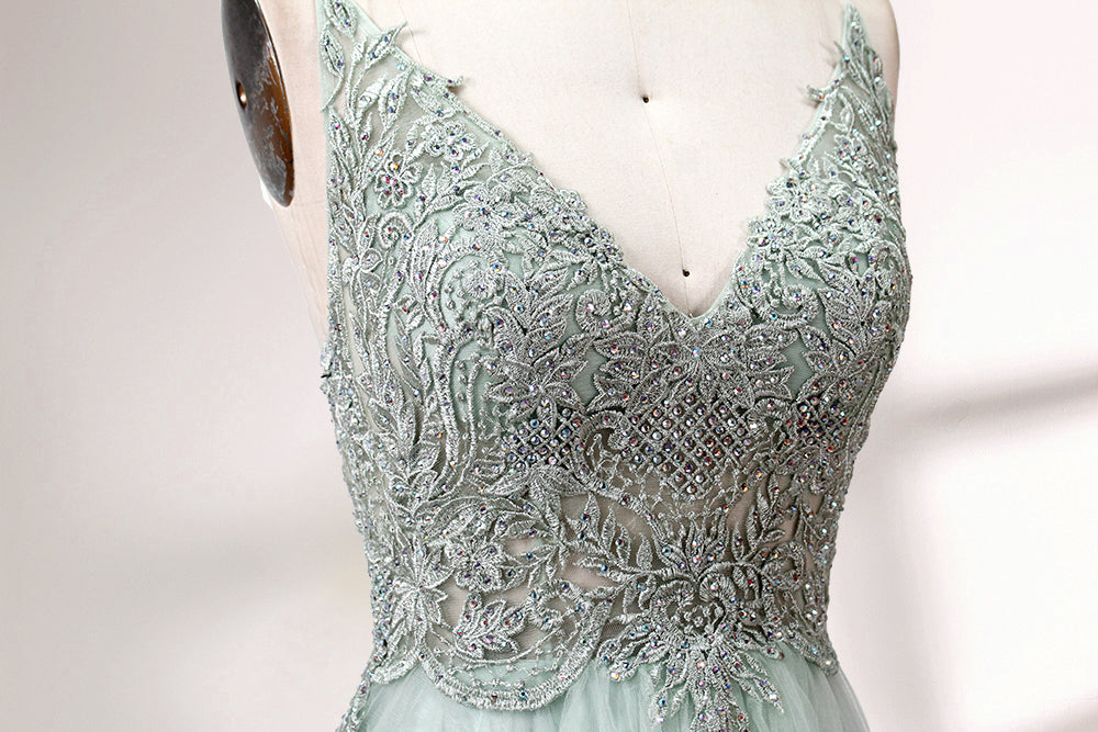 A mannequin showcases a light - green tulle gown with a lace - embroidered, sheer bodice. It has thin straps, a deep V - neckline, and a voluminous skirt. The delicate lace and flowing tulle create a romantic look, perfect for formal events like weddings or proms, exuding elegance.
5