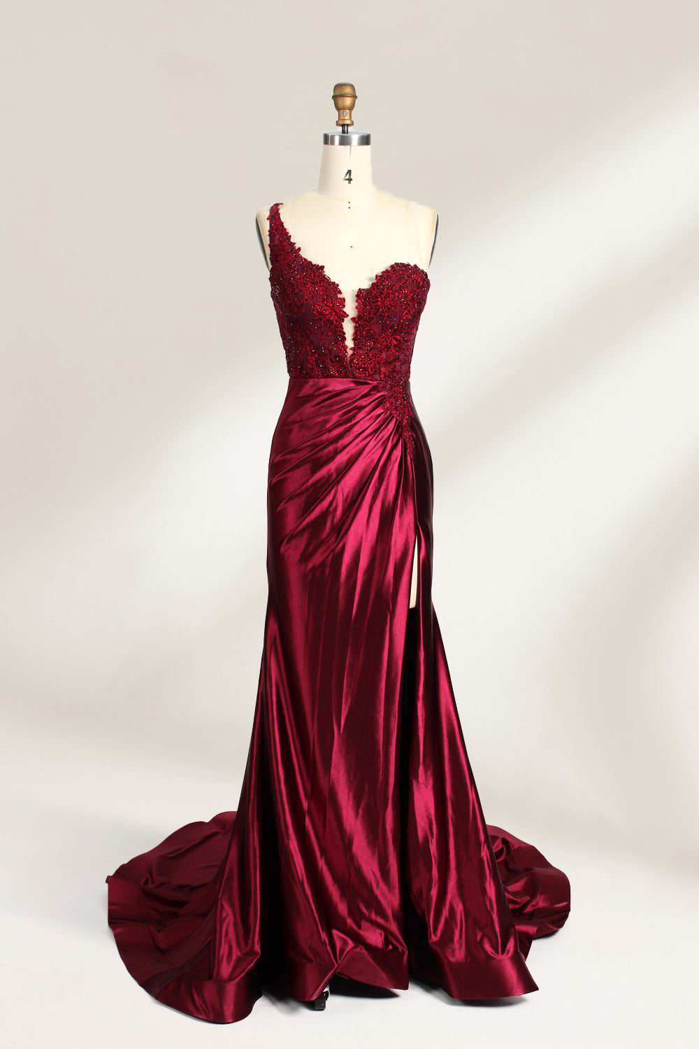 A mannequin displays a teal satin gown. It features a deep V - neckline with lace embroidery on the bodice, a ruched skirt, and a mermaid silhouette. The elegant details and shiny fabric create a glamorous look, perfect for formal events like proms or galas.6