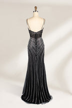 A mannequin showcases a black gown with silver beading. It has thin straps, a sheer bodice, and a high side slit. The geometric beading pattern adds glamour, making it perfect for formal events like galas or proms, radiating sophistication.2