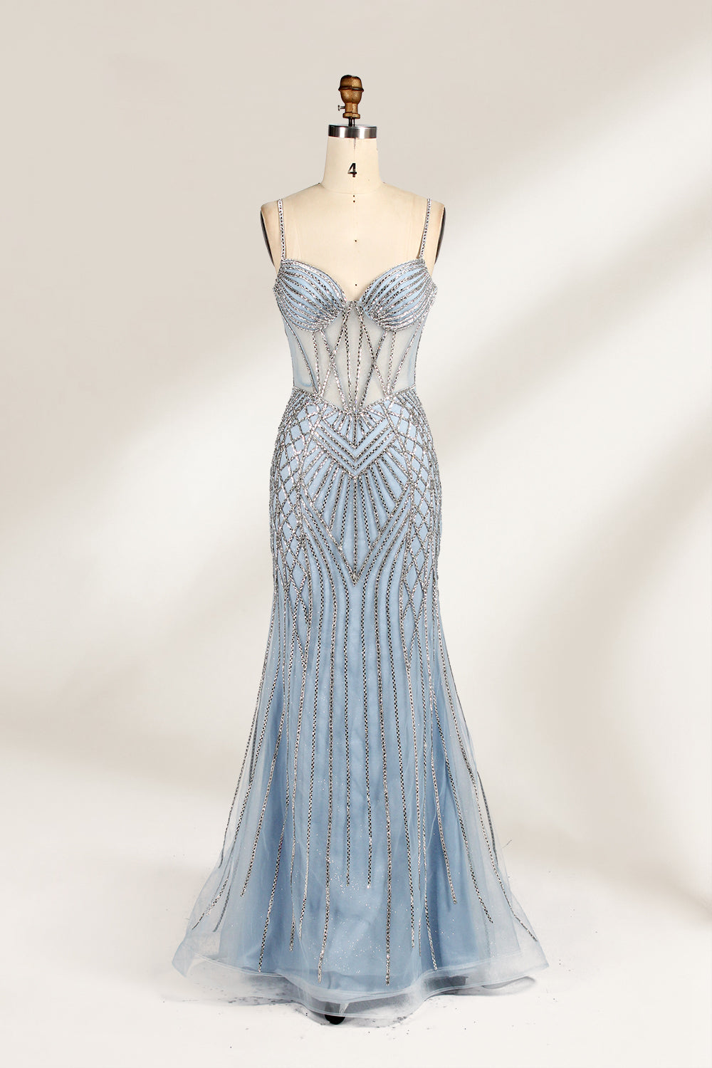 A close - up of a light - blue tulle gown with intricate silver beading. It has a strapless, sweetheart neckline and sheer bodice. The geometric beading pattern adds glamour, perfect for formal events like galas, radiating charm.1