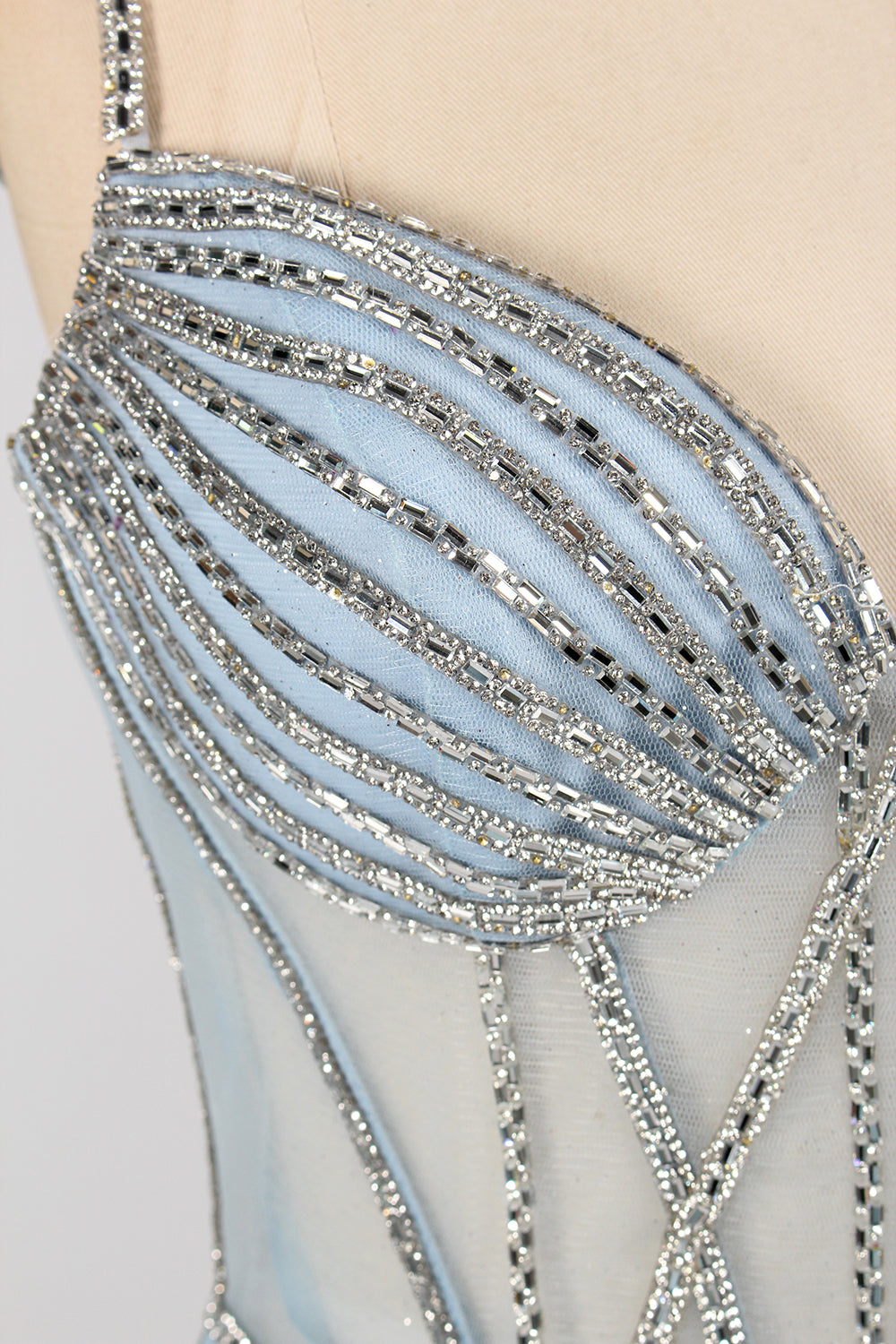 A close - up of a light - blue tulle gown with intricate silver beading. It has a strapless, sweetheart neckline and sheer bodice. The geometric beading pattern adds glamour, perfect for formal events like galas, radiating charm.4