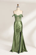 A mannequin showcases an olive - green gown. It has off - the - shoulder, lace - detailed sleeves, a sheer bodice with floral embroidery, and a high side slit. The elegant design, blending satin and lace, suits formal events like galas, radiating charm.1
