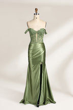 A mannequin showcases an olive - green gown. It has off - the - shoulder, lace - detailed sleeves, a sheer bodice with floral embroidery, and a high side slit. The elegant design, blending satin and lace, suits formal events like galas, radiating charm.1