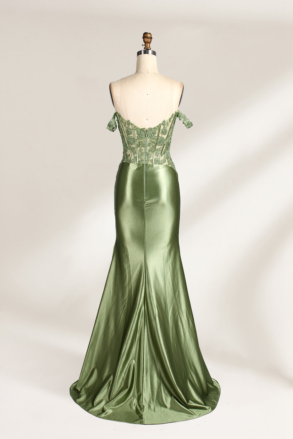 A mannequin showcases an olive - green gown. It has off - the - shoulder, lace - detailed sleeves, a sheer bodice with floral embroidery, and a high side slit. The elegant design, blending satin and lace, suits formal events like galas, radiating charm.A mannequin showcases an olive - green gown. It has off - the - shoulder, lace - detailed sleeves, a sheer bodice with floral embroidery, and a high side slit. The elegant design, blending satin and lace, suits formal events like galas, radiating charm.2