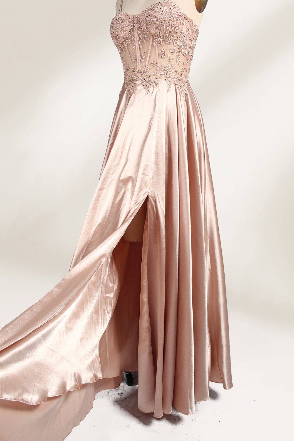 A mannequin showcases a champagne - satin gown. It has thin straps, a sheer lace - detailed bodice, and a voluminous skirt. The elegant design, blending satin and intricate lace, suits formal events like weddings, radiating sophistication.2