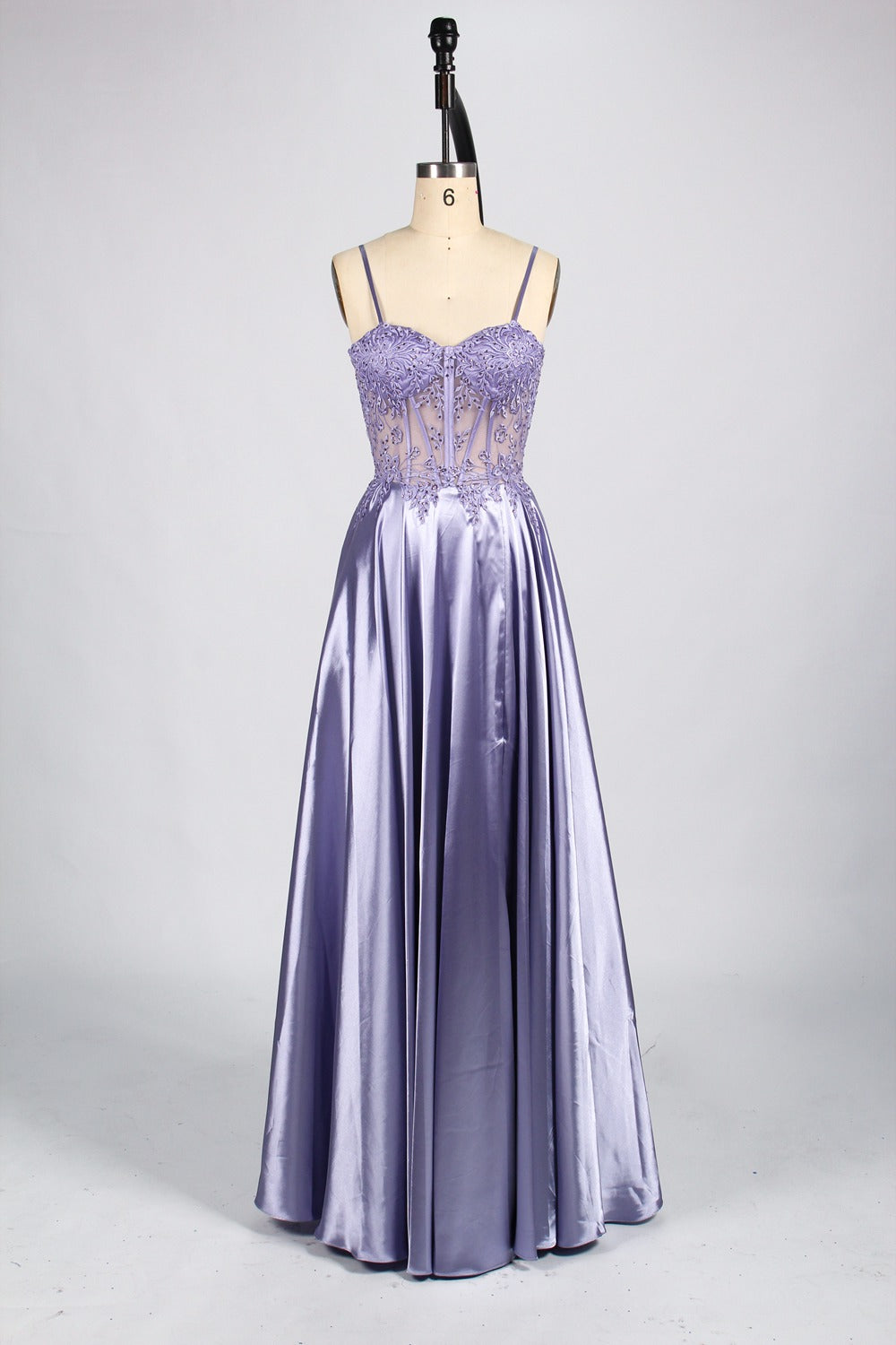 A mannequin showcases a champagne - satin gown. It has thin straps, a sheer lace - detailed bodice, and a voluminous skirt. The elegant design, blending satin and intricate lace, suits formal events like weddings, radiating sophistication.8