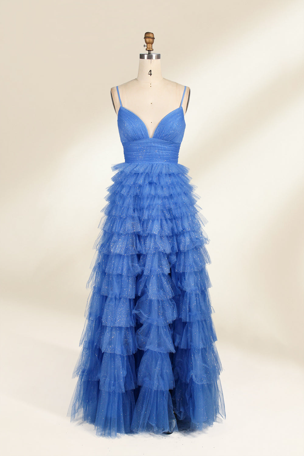 A mannequin showcases a light - blue tulle gown. It has thin straps, a V - neck, and tiered, ruffled skirt. The sparkling tulle and layered design add romance, perfect for formal events like weddings, radiating charm.1