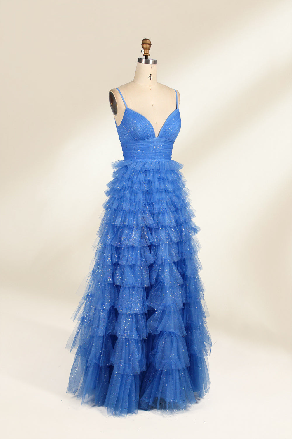 A mannequin showcases a light - blue tulle gown. It has thin straps, a V - neck, and tiered, ruffled skirt. The sparkling tulle and layered design add romance, perfect for formal events like weddings, radiating charm.3