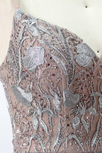 Showcased on a mannequin is a taupe - toned mermaid - cut gown. It has thin straps, a sweetheart neckline, and is embellished with delicate silver floral embroidery all over, plus a flowing tulle skirt. The refined design gives off a glamorous aura, ideal for formal events such as proms or weddings.7
