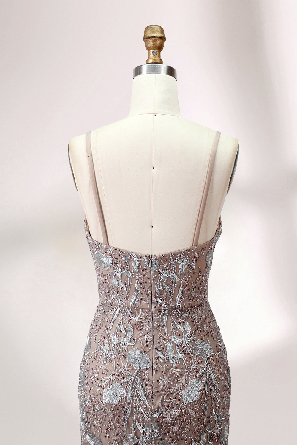 Showcased on a mannequin is a taupe - toned mermaid - cut gown. It has thin straps, a sweetheart neckline, and is embellished with delicate silver floral embroidery all over, plus a flowing tulle skirt. The refined design gives off a glamorous aura, ideal for formal events such as proms or weddings.5