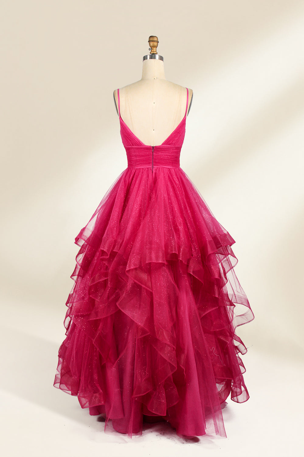 A mannequin showcases a magenta - tulle gown. It has thin straps, a V - neck, and tiered, ruffled skirt. The sparkling tulle and layered design add romance, perfect for formal events like proms, radiating glamour.2