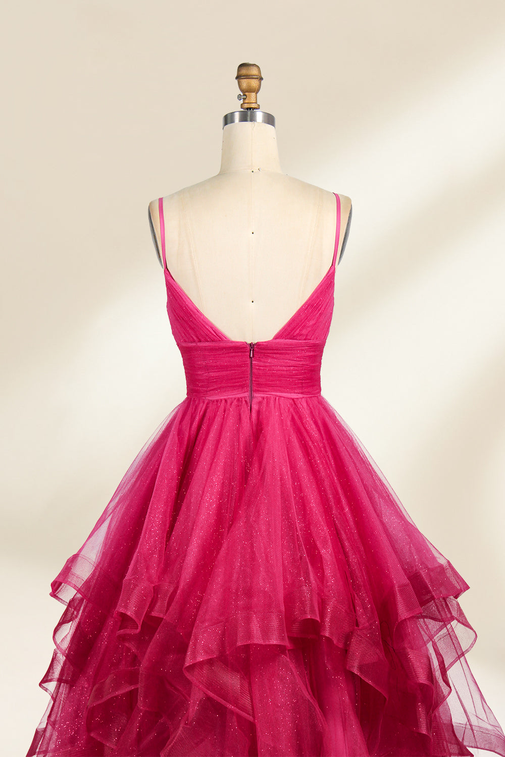 A mannequin showcases a magenta - tulle gown. It has thin straps, a V - neck, and tiered, ruffled skirt. The sparkling tulle and layered design add romance, perfect for formal events like proms, radiating glamour.6