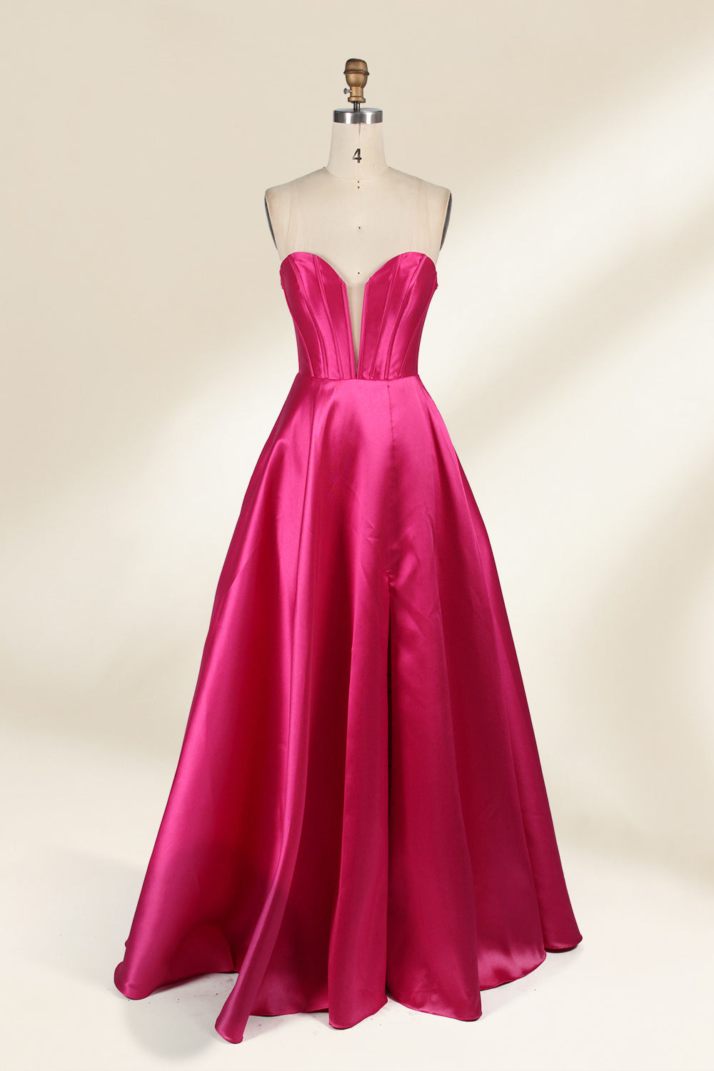 A mannequin showcases a magenta - satin gown. It has an off - the - shoulder, sweetheart neckline, puffed sleeves, and a high side slit. The elegant design, with smooth satin fabric, suits formal events like galas, radiating sophistication.3
