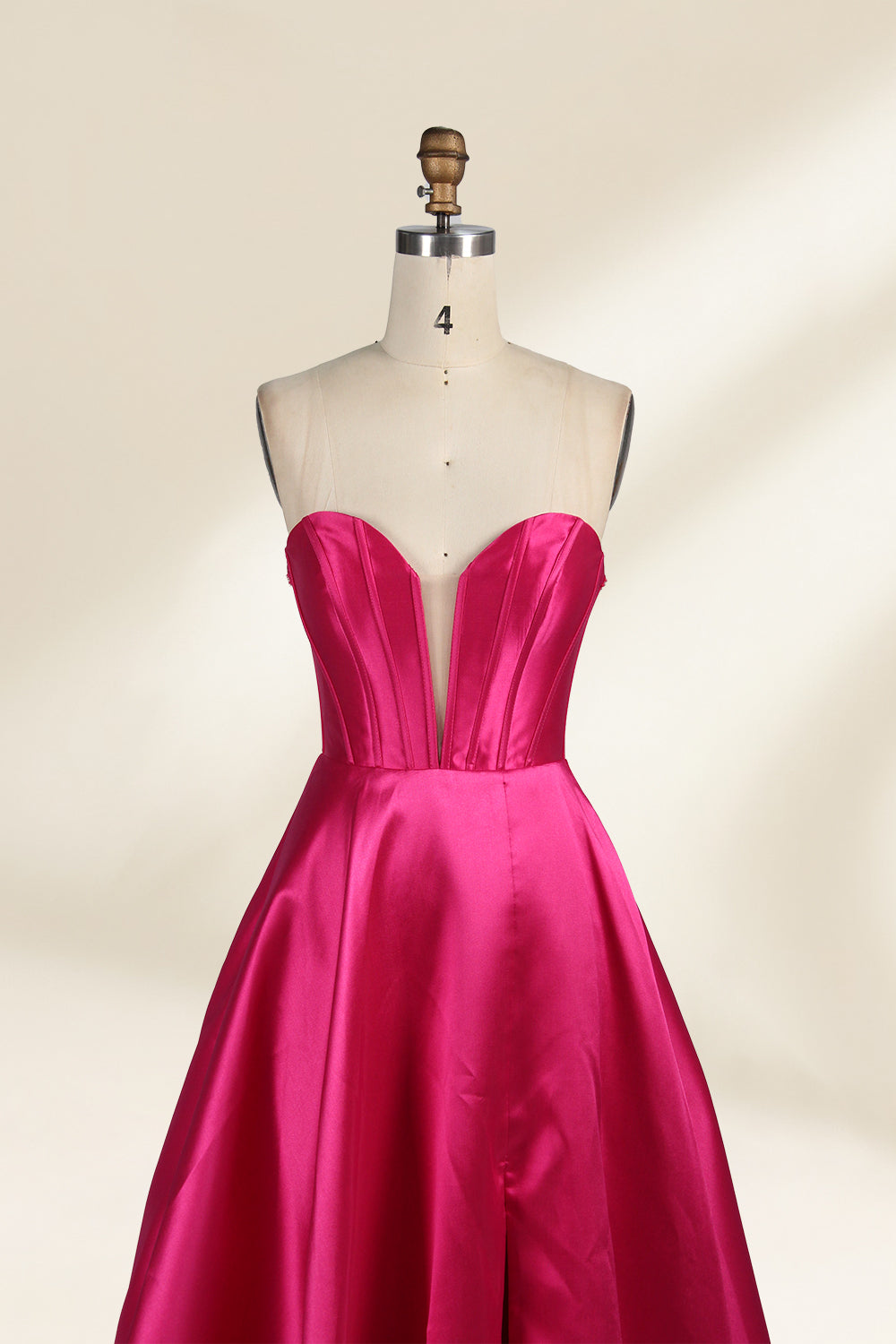 A mannequin showcases a magenta - satin gown. It has an off - the - shoulder, sweetheart neckline, puffed sleeves, and a high side slit. The elegant design, with smooth satin fabric, suits formal events like galas, radiating sophistication.6