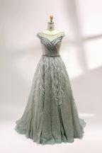 Displayed on a mannequin is a light - green evening gown. It features a sheer neckline with feather and bead embellishments, and a voluminous, glittering skirt. The elegant design creates a dreamy and luxurious look, perfect for formal events.1