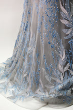 Presented on a mannequin is a gown with a gray base and rich red floral embroidery. It features a sheer neckline, a sleeveless design, and an intricate pattern that gives off a romantic and elegant vibe, perfect for formal events.8
