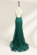 Photograph of a dark green, floor-length evening gown displayed on a white dress form. The gown features a deep V-neckline with thin spaghetti straps, a fitted bodice adorned with intricate lace detailing, and a flowing, slightly flared skirt. The dress showcases a rich, textured fabric with a shimmering effect, accentuating the luxurious and elegant style. The background is a plain, off-white color, ensuring the dress remains the focal point.03