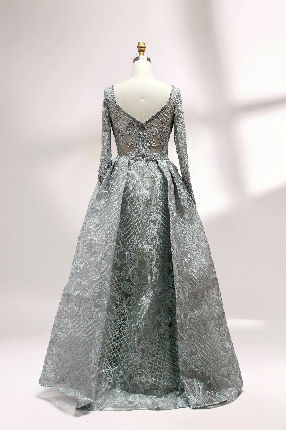 Showcased on a mannequin is a silver - gray evening gown. It has a V - neckline, long sleeves, and intricate lace embroidery all over. The elaborate design gives off a luxurious and elegant vibe, ideal for formal occasions.2