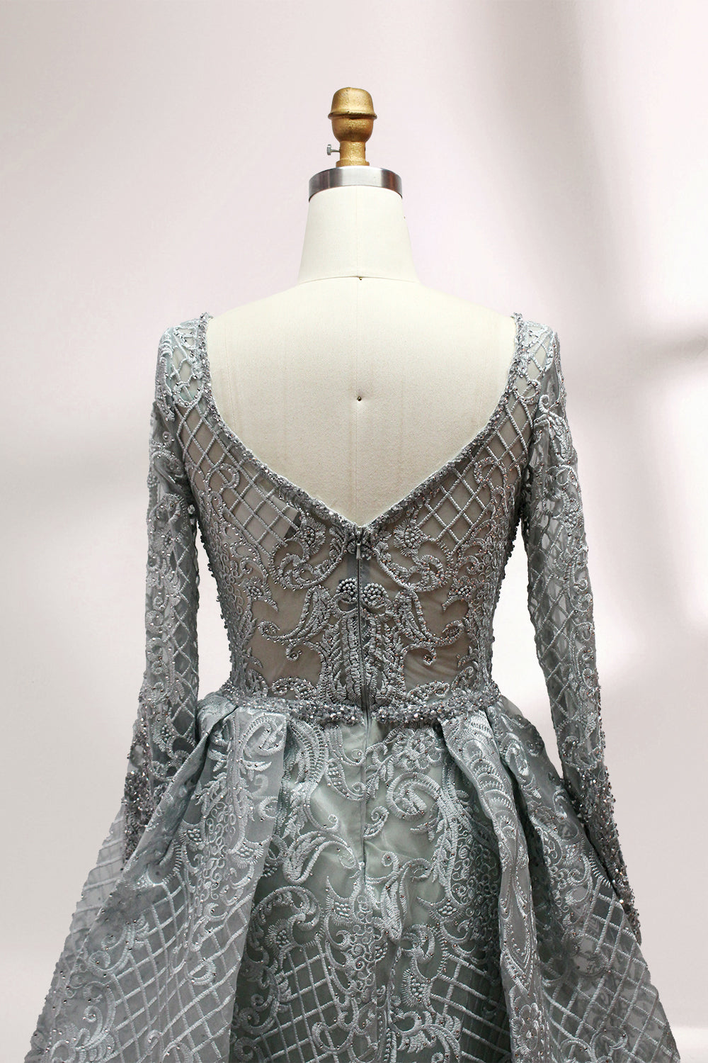 Showcased on a mannequin is a silver - gray evening gown. It has a V - neckline, long sleeves, and intricate lace embroidery all over. The elaborate design gives off a luxurious and elegant vibe, ideal for formal occasions.6
