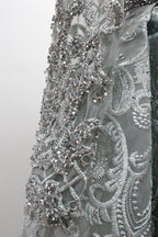 Showcased on a mannequin is a silver - gray evening gown. It has a V - neckline, long sleeves, and intricate lace embroidery all over. The elaborate design gives off a luxurious and elegant vibe, ideal for formal occasions.10