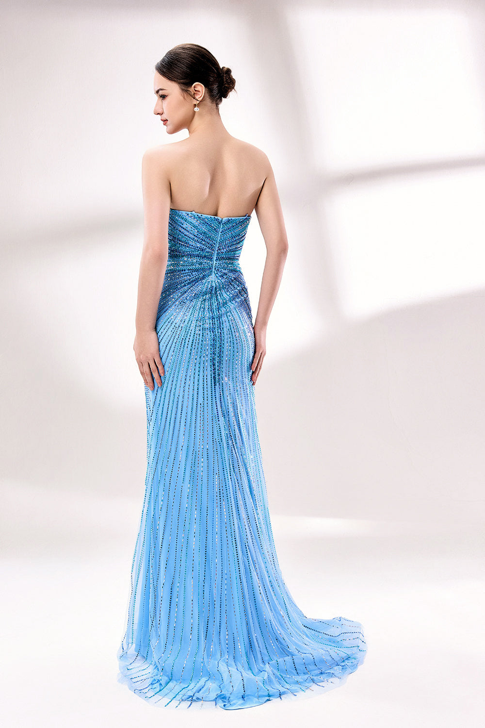photo of a beautiful woman in a stunning blue ball gown with a plunging neckline and thigh-high slit, standing confidently in a studio with soft, diffused lighting, elegant and glamorous, full-length dress with intricate beadwork, long brunette hair styled in an elegant updo, fair skin, red lipstick, high heels, minimalist white background, fashion photography, stylish and sophisticated, no watermarks.KT1432-02