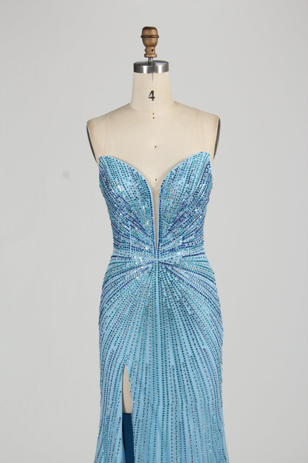 photo of a beautiful woman in a stunning blue ball gown with a plunging neckline and thigh-high slit, standing confidently in a studio with soft, diffused lighting, elegant and glamorous, full-length dress with intricate beadwork, long brunette hair styled in an elegant updo, fair skin, red lipstick, high heels, minimalist white background, fashion photography, stylish and sophisticated, no watermarks.KT1432-09