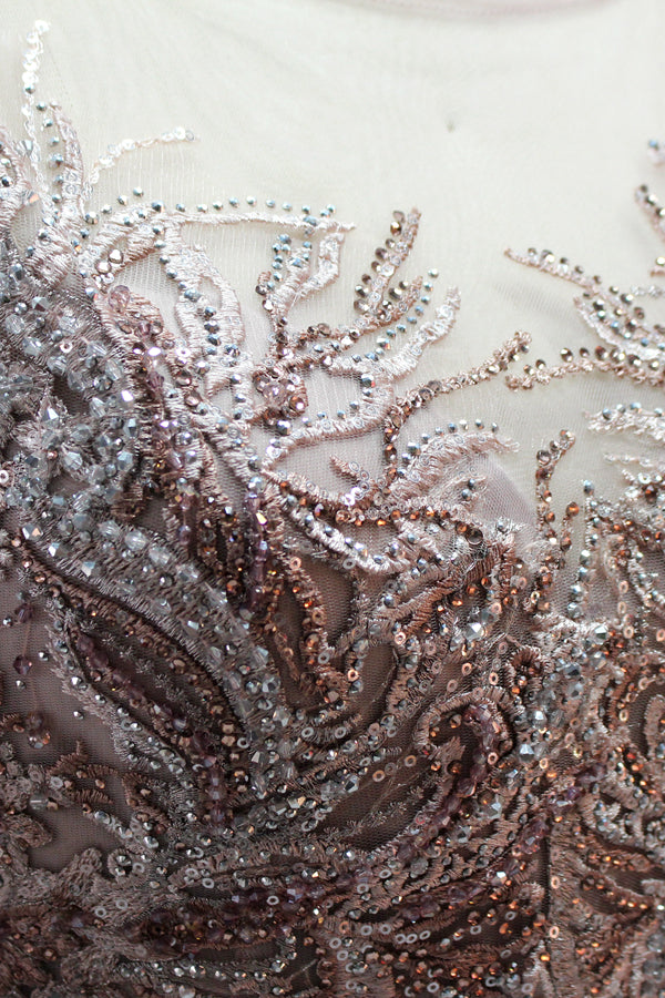 Presented on a mannequin is a deep - red evening gown. It features a sheer neckline, long billowy sleeves, and intricate gold - toned embroidery throughout. The elaborate design gives off a luxurious and elegant vibe, ideal for formal occasions.6