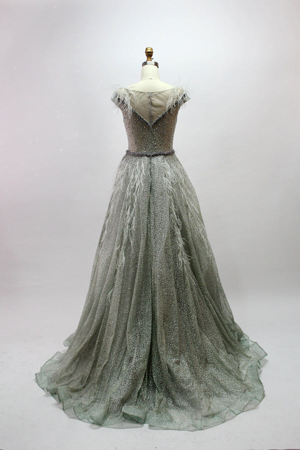 Displayed on a mannequin is a light - green evening gown. It features a sheer neckline with feather and bead embellishments, and a voluminous, glittering skirt. The elegant design creates a dreamy and luxurious look, perfect for formal events.3