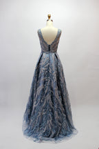 Presented on a mannequin is a mauve evening gown. It features a deep V - neckline, intricate floral embroidery with bead accents, and a flowing skirt. The elegant design creates a romantic and sophisticated look, perfect for formal events.3