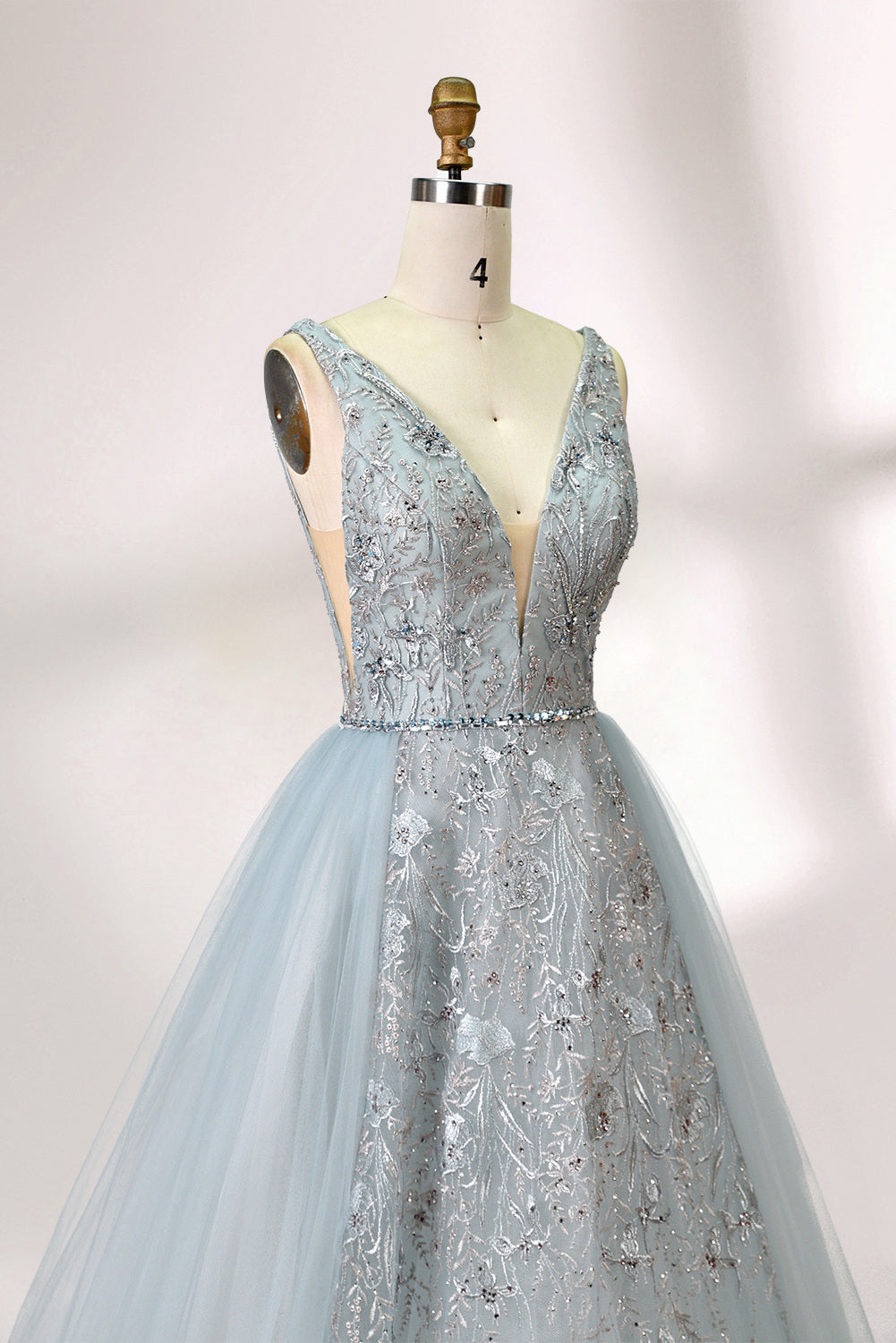Presented on a mannequin is a light blue ball - gown - style dress. It features a deep V - neckline, with the bodice adorned by delicate silver embroidery, and a flowing tulle skirt. The graceful design exudes a romantic and luxurious charm, ideal for formal occasions such as proms or weddings.
2