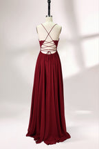 Displayed on a mannequin is a burgundy gown. It features spaghetti straps, a lace - adorned bodice, and a flowing chiffon skirt with a slit. The elegant design suits formal events like galas or weddings.5