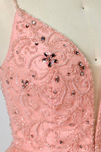 Photograph of a mannequin wearing an elegant, floor-length, blush pink tulle gown with a fitted bodice adorned with sequin embellishments and thin spaghetti straps. The gown has a sweetheart neckline and a full skirt with a subtle sparkle, creating a soft, ethereal effect. The background is a plain white studio setting with soft lighting casting gentle shadows.06