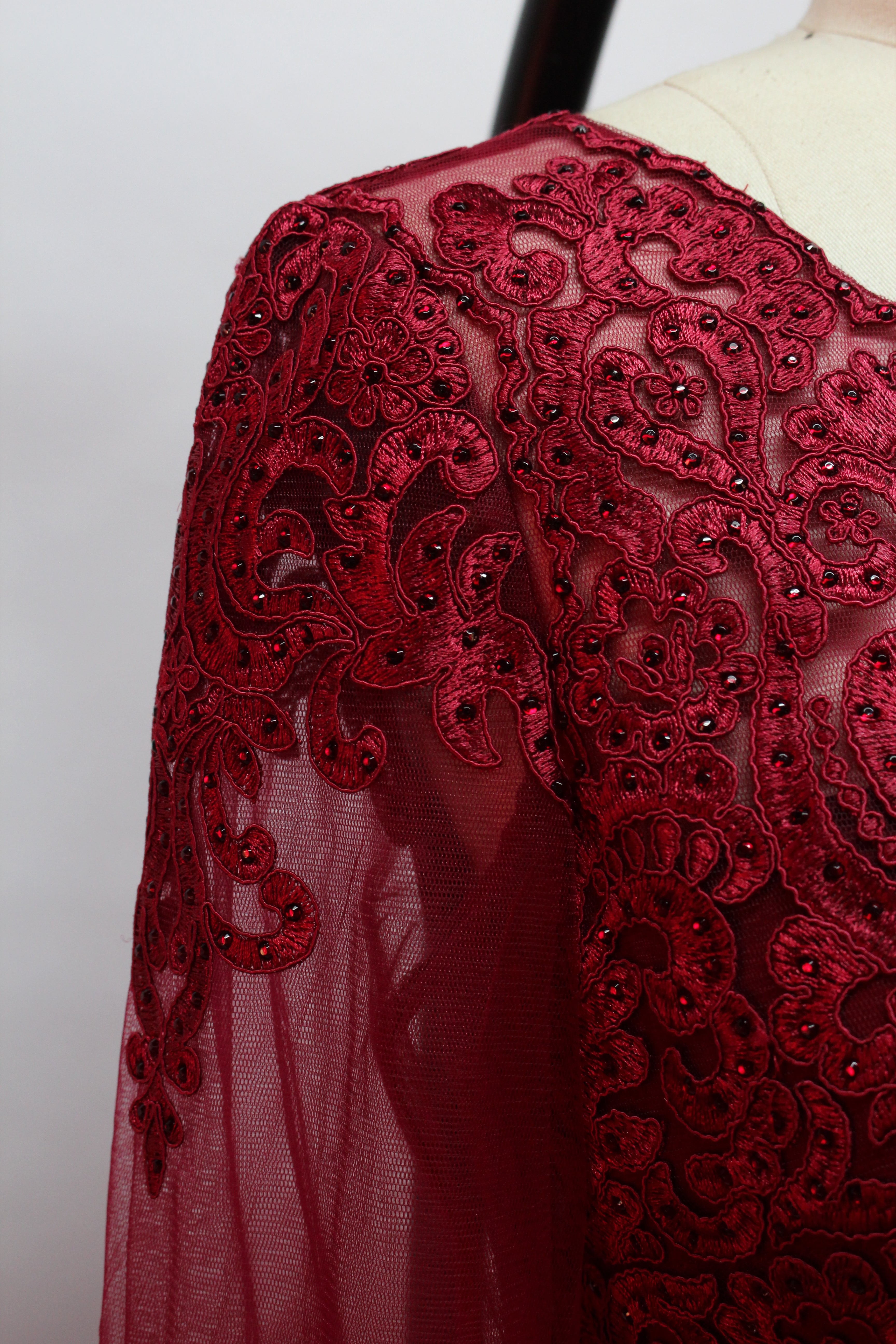 Front view of an elegant burgundy A-line mother of the bride dress featuring a scoop neck bodice with intricate beaded lace detailing, sheer long chiffon sleeves, and a long flowing floor-length chiffon skirt, suitable for weddings and formal evening galas and available for wholesale or bulk purchase.