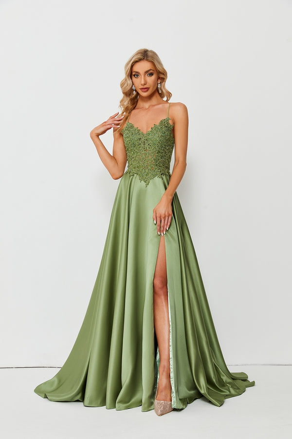 A beautiful blonde woman, standing against a plain white background, wearing a stunning green ball gown with a high slit, lace detailing on the top, elegant and classy, long wavy hair, light makeup, wearing high heels, full body shot, studio lighting, fashion photography, elegant and sophisticated, glamorous, formal attire, no watermark, simple background, no accessories